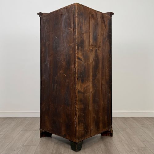 fig 3. A tall 18th-century Georgian dark mahogany corner cabinet featuring panelled double doors, a moulded cornice, and bracket feet.