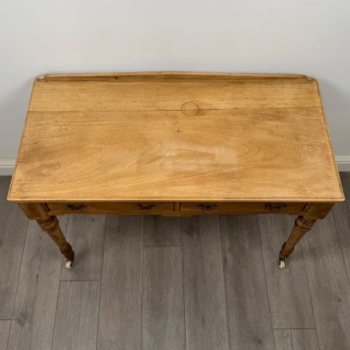 fig 8. A 19th-century Victorian pine writing table featuring two drawers with brass handles, turned wooden legs, and ceramic castors.