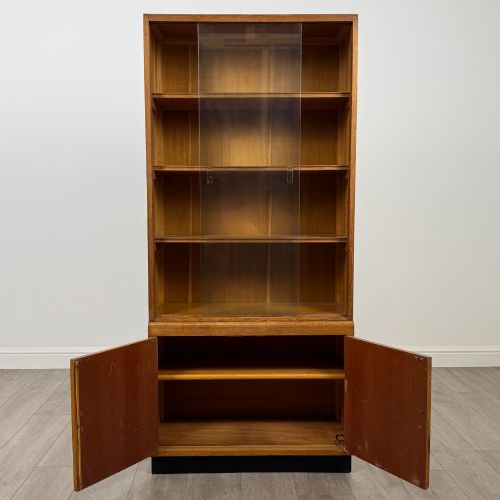 fig 2. A tall vintage golden oak display cabinet featuring glazed sliding doors on top and a two-door cupboard base.