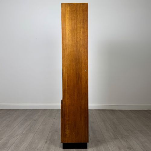 fig 4. A tall vintage golden oak display cabinet featuring glazed sliding doors on top and a two-door cupboard base.