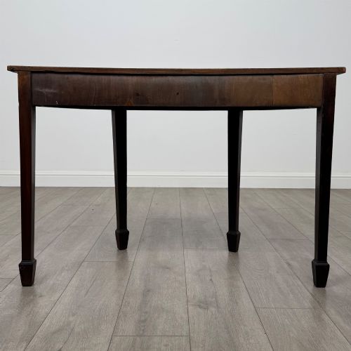 fig 3. A nineteenth-century mahogany demi-lune side table featuring a semi-circular top, a veneered apron, and four square tapered legs ending in spade feet.