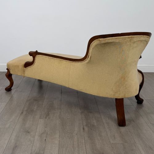 fig 5. A Victorian mahogany chaise longue featuring ochre velvet button-backed upholstery, carved trim, and cabriole legs.