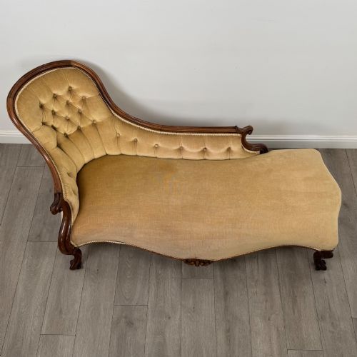 fig 8. A Victorian mahogany chaise longue featuring ochre velvet button-backed upholstery, carved trim, and cabriole legs.