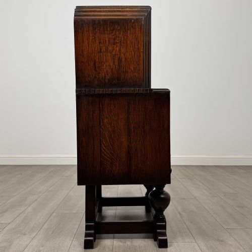 fig 7. An early 20th-century dark oak writing bureau featuring a sloped fall-front lid above two drawers, supported on turned bulbous legs with stretchers.