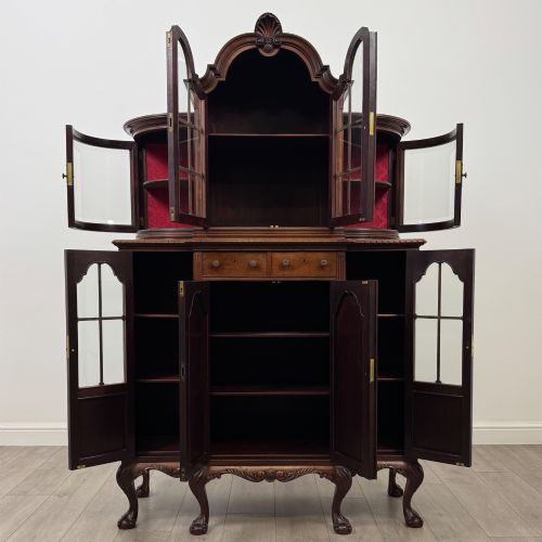 fig 1. A 19th-century Queen Anne style dark walnut display cabinet featuring curved glass side sections, an arched central glazed door with a carved shell crest, and cabriole legs.