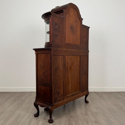 fig 4. A 19th-century Queen Anne style dark walnut display cabinet featuring curved glass side sections, an arched central glazed door with a carved shell crest, and cabriole legs.