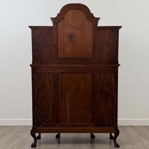 fig 5. A 19th-century Queen Anne style dark walnut display cabinet featuring curved glass side sections, an arched central glazed door with a carved shell crest, and cabriole legs.