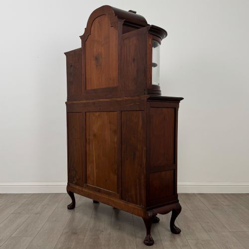 fig 6. A 19th-century Queen Anne style dark walnut display cabinet featuring curved glass side sections, an arched central glazed door with a carved shell crest, and cabriole legs.