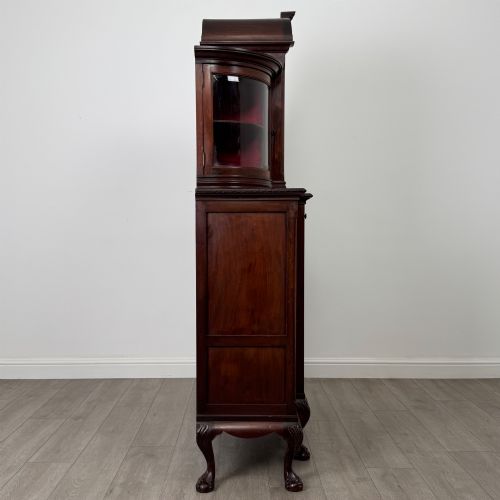 fig 7. A 19th-century Queen Anne style dark walnut display cabinet featuring curved glass side sections, an arched central glazed door with a carved shell crest, and cabriole legs.