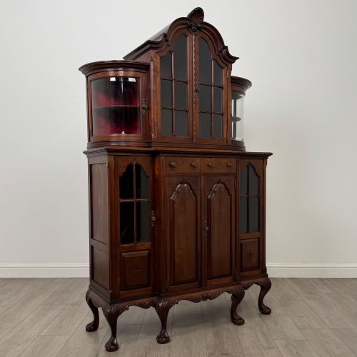 fig 8. A 19th-century Queen Anne style dark walnut display cabinet featuring curved glass side sections, an arched central glazed door with a carved shell crest, and cabriole legs.