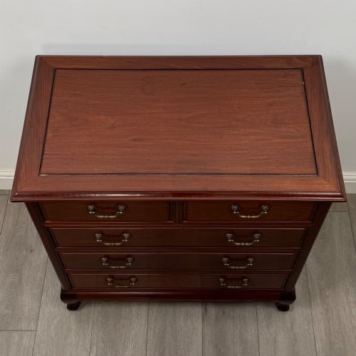 fig 8. A mahogany chest of drawers featuring a two-over-three drawer arrangement supported on cabriole feet with brass drop handles.