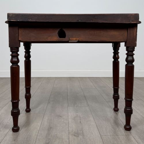 fig 4. A Victorian mahogany writing table featuring two frieze drawers with brass knob handles, turned legs, and a low gallery back.