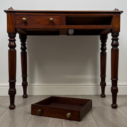 fig 9. A Victorian mahogany writing table featuring two frieze drawers with brass knob handles, turned legs, and a low gallery back.