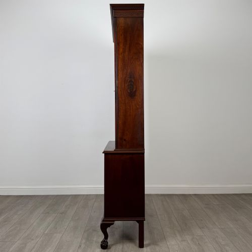 fig 3. A 20th-century Chippendale style mahogany bookcase featuring two upper glazed doors with diamond pattern astragal glazing and a two-door cupboard base raised on cabriole legs with claw and ball feet.