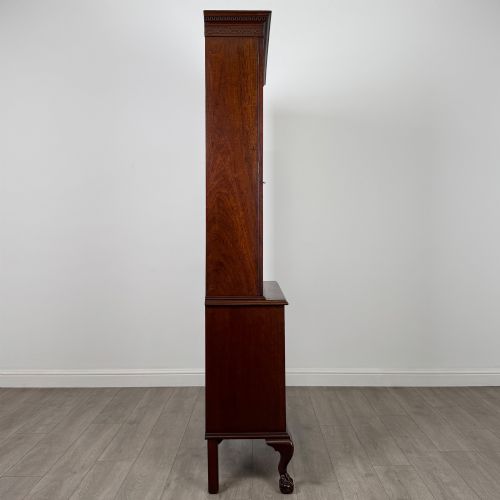 fig 7. A 20th-century Chippendale style mahogany bookcase featuring two upper glazed doors with diamond pattern astragal glazing and a two-door cupboard base raised on cabriole legs with claw and ball feet.
