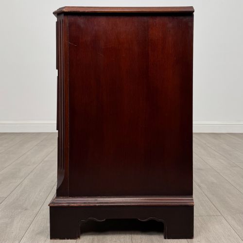 fig 2. A 20th-century American mahogany chest of drawers featuring two small top drawers, two full-width lower drawers, brass bail handles, fluted quarter-columns, and bracket feet.