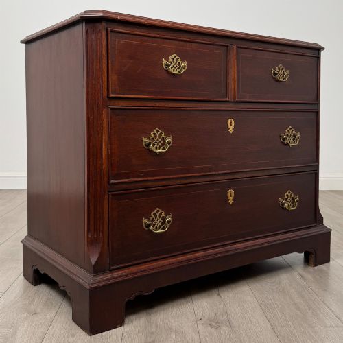 fig 7. A 20th-century American mahogany chest of drawers featuring two small top drawers, two full-width lower drawers, brass bail handles, fluted quarter-columns, and bracket feet.