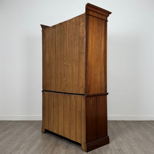 fig 6. An Edwardian walnut linen press featuring a moulded top cornice, two large upper recessed panel doors, and a lower chest of drawers with brass drop handles.
