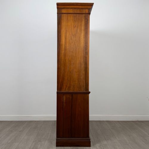 fig 7. An Edwardian walnut linen press featuring a moulded top cornice, two large upper recessed panel doors, and a lower chest of drawers with brass drop handles.