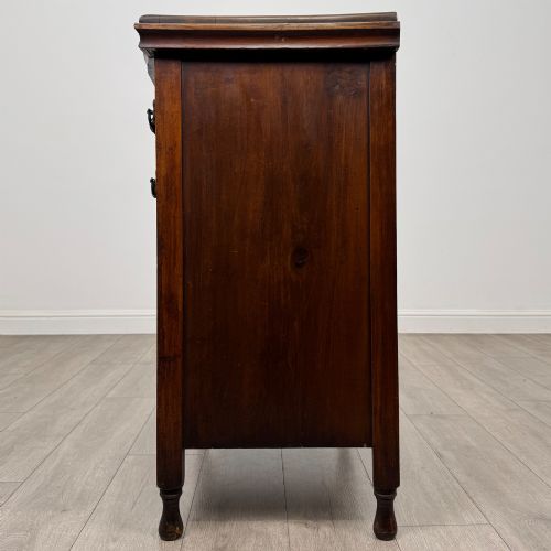 fig 2. A 19th-century Victorian walnut chest of drawers featuring ornate relief carvings across the drawer fronts and metal drop handles.