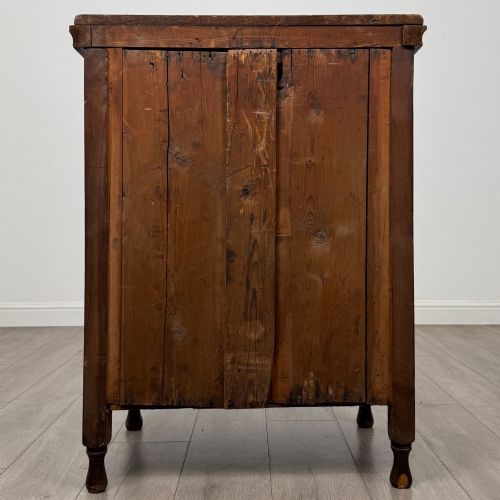 fig 4. A 19th-century Victorian walnut chest of drawers featuring ornate relief carvings across the drawer fronts and metal drop handles.