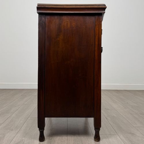fig 6. A 19th-century Victorian walnut chest of drawers featuring ornate relief carvings across the drawer fronts and metal drop handles.