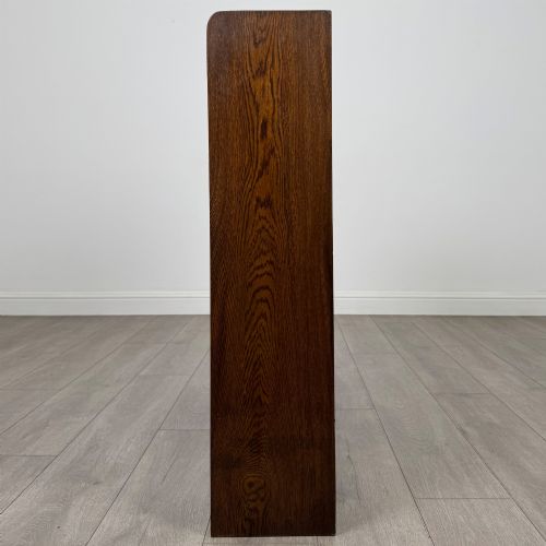 fig 3. A mid-twentieth-century dark oak display cabinet featuring three interior shelf tiers enclosed by sliding glass doors.