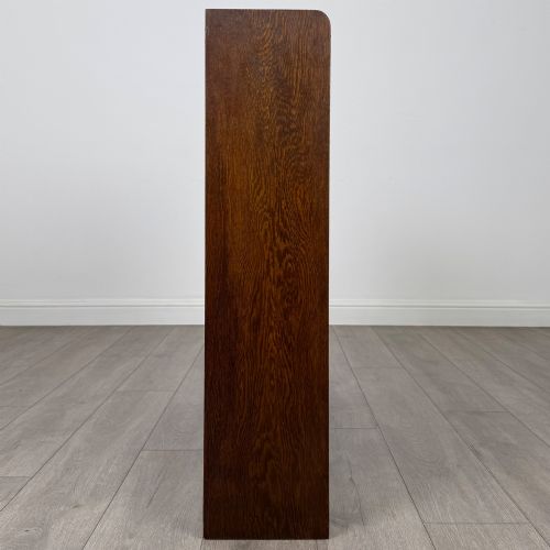 fig 7. A mid-twentieth-century dark oak display cabinet featuring three interior shelf tiers enclosed by sliding glass doors.