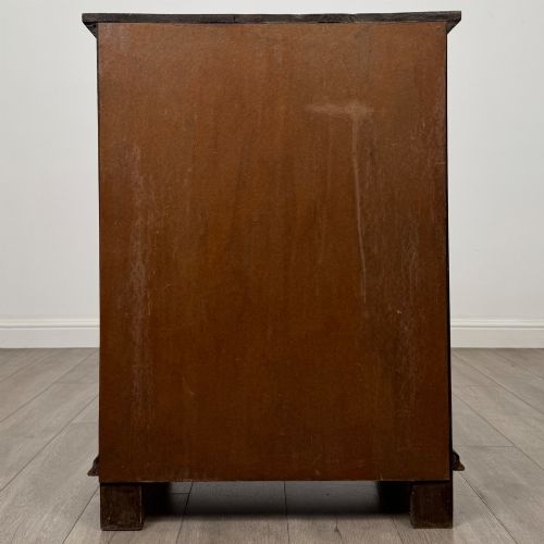 fig 5. A small dark oak cupboard featuring a single carved top drawer above a panelled cupboard door with iron hinges.