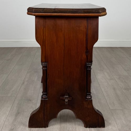 fig 1. An antique 19th-century pitch pine side table featuring a Gothic Revival trestle base with turned column details and a pegged stretcher.