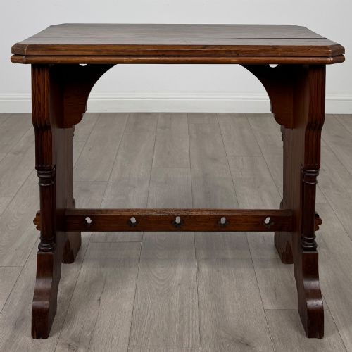 fig 2. An antique 19th-century pitch pine side table featuring a Gothic Revival trestle base with turned column details and a pegged stretcher.