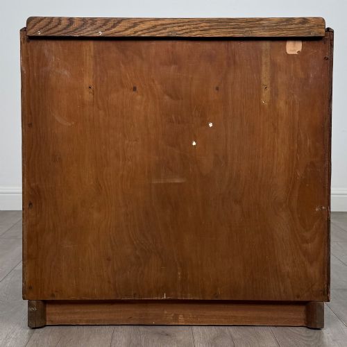 fig 4. An antique golden oak chest of four drawers fitted with decorative brass drop handles on a plinth base.
