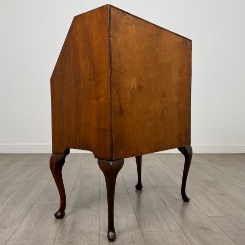 fig 4. An antique Edwardian burr walnut slant-front bureau featuring two drawers with metal handles, supported by carved cabriole legs.