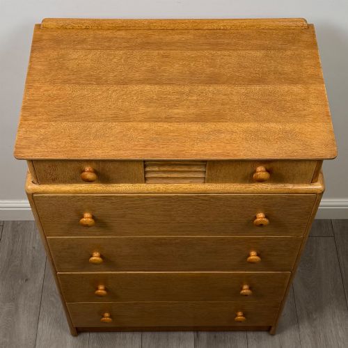 fig 8. A twentieth-century oak chest featuring four large horizontal drawers below two smaller upper drawers with turned wooden handles and a central carved fluted detail.