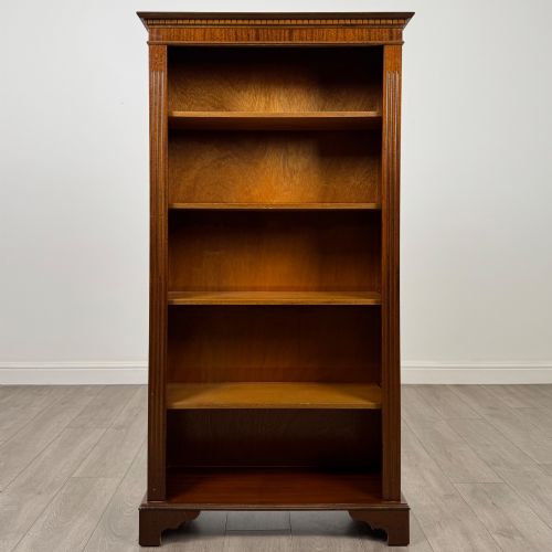 fig 1. A tall early 20th-century mahogany open bookcase featuring fluted side pilasters, a crossbanded cornice, five shelves, and bracket feet.