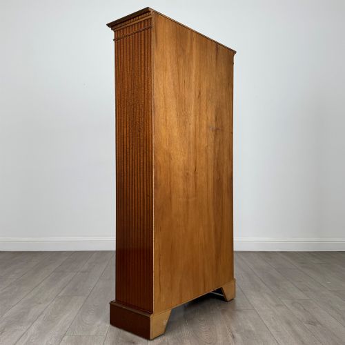 fig 4. A tall early 20th-century mahogany open bookcase featuring fluted side pilasters, a crossbanded cornice, five shelves, and bracket feet.