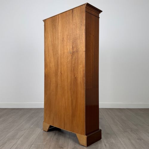 fig 6. A tall early 20th-century mahogany open bookcase featuring fluted side pilasters, a crossbanded cornice, five shelves, and bracket feet.