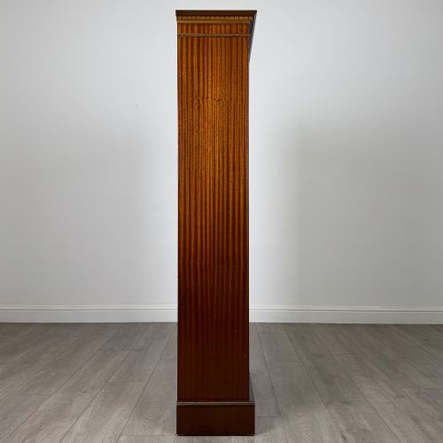 fig 7. A tall early 20th-century mahogany open bookcase featuring fluted side pilasters, a crossbanded cornice, five shelves, and bracket feet.