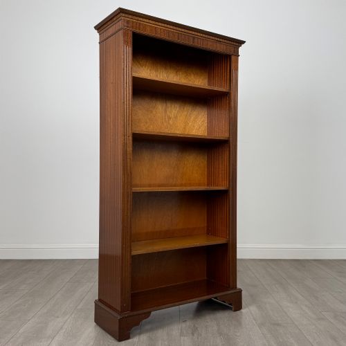 fig 8. A tall early 20th-century mahogany open bookcase featuring fluted side pilasters, a crossbanded cornice, five shelves, and bracket feet.