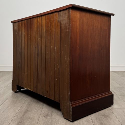 fig 5. An antique mahogany chest of drawers featuring two short top drawers over two long lower drawers with decorative metal handles on a plinth base.