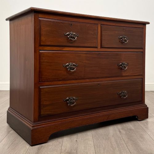 fig 7. An antique mahogany chest of drawers featuring two short top drawers over two long lower drawers with decorative metal handles on a plinth base.