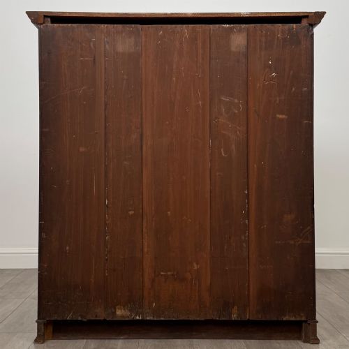 fig 5. An antique early twentieth-century two-door walnut linen cupboard featuring double panelled doors, a moulded top cornice, and a central brass teardrop handle.
