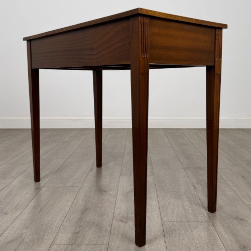 fig 5. A 20th-century burr walnut side table featuring a serpentine front, three drawer fronts with brass handles, and square tapered legs.