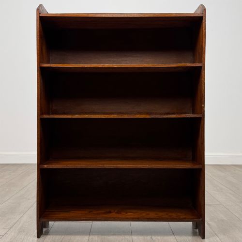 fig 1. An Edwardian dark oak open bookcase featuring four fixed shelves and shaped side panels.