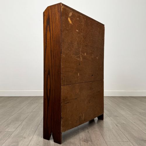 fig 4. An Edwardian dark oak open bookcase featuring four fixed shelves and shaped side panels.