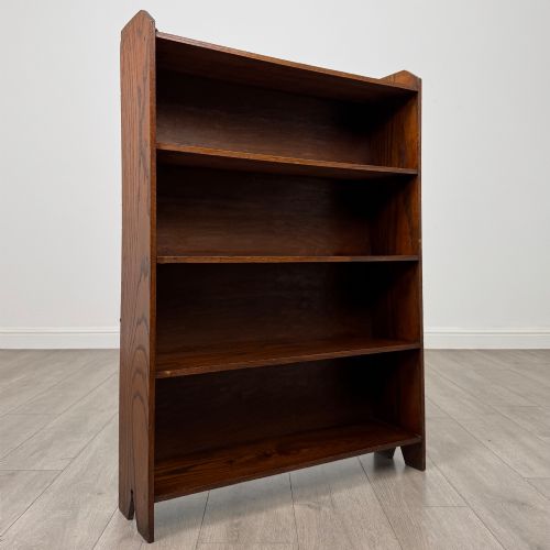 fig 8. An Edwardian dark oak open bookcase featuring four fixed shelves and shaped side panels.