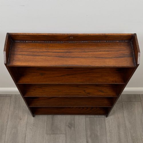 fig 9. An Edwardian dark oak open bookcase featuring four fixed shelves and shaped side panels.