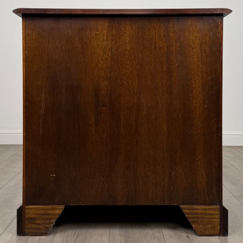 fig 4. A 20th-century serpentine-front hardwood chest featuring four stacked drawers with brass drop ring handles and central brass escutcheons.