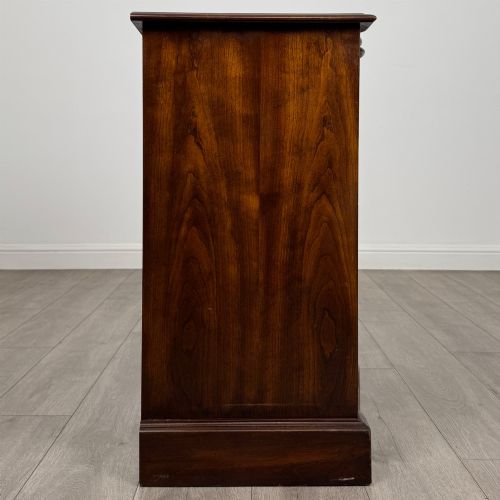 fig 6. A 20th-century serpentine-front hardwood chest featuring four stacked drawers with brass drop ring handles and central brass escutcheons.