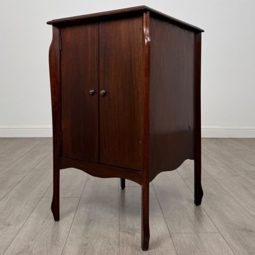 fig 2. An antique Edwardian mahogany cabinet with double panelled doors, brass knobs, and elevated curved legs.